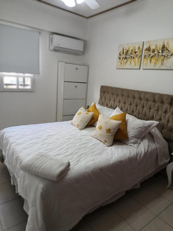 a bedroom with a large bed with yellow pillows at HERMOSO DPTO 2 dor TUCUMAN in San Miguel de Tucumán