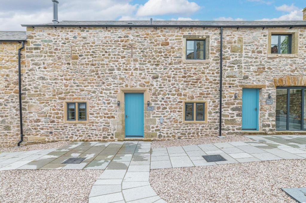 a stone building with blue doors on it at No 2 The Coach House in Carnforth
