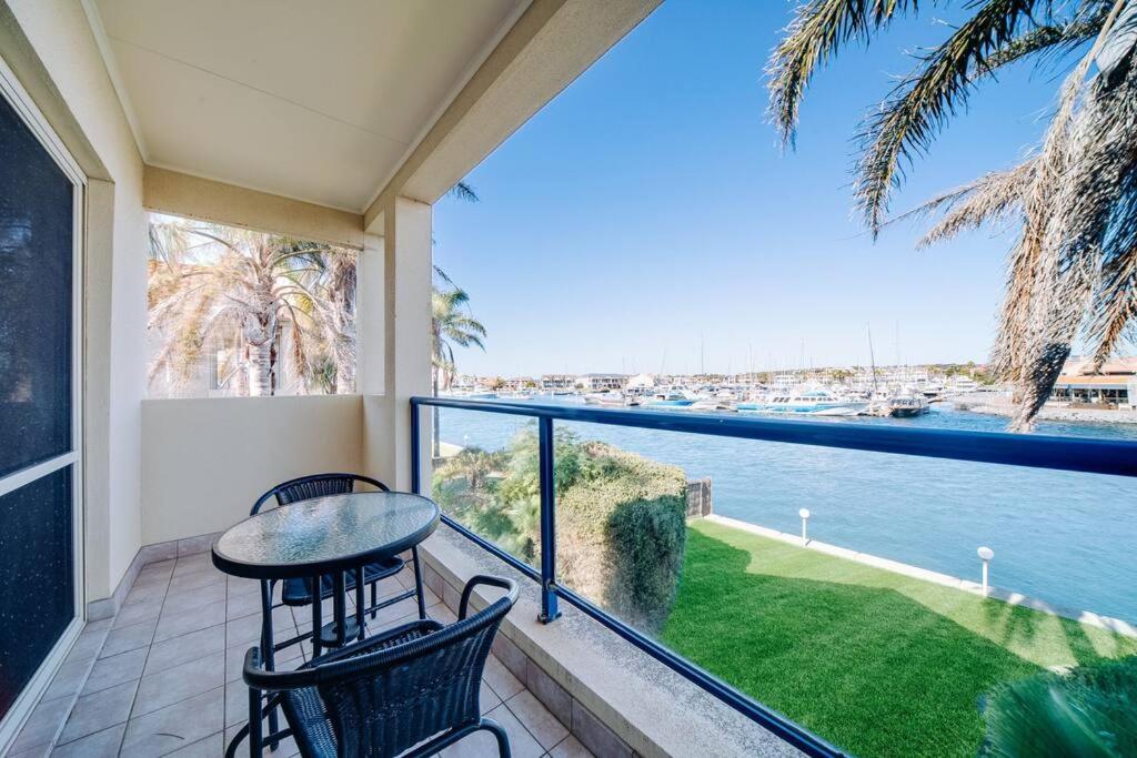 a balcony with a table and chairs and a view of the water at Waterfront Townhouse - One in Port Lincoln
