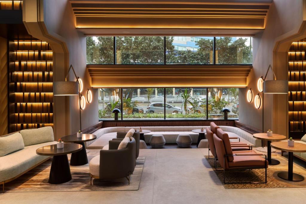 a lobby with couches and tables and a large window at Casablanca Marriott Hotel in Casablanca