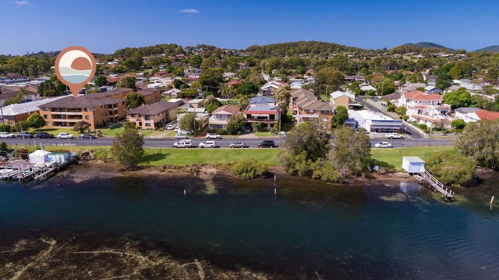 una vista aérea de una ciudad con un lago y casas en Akuna 8 en Forster