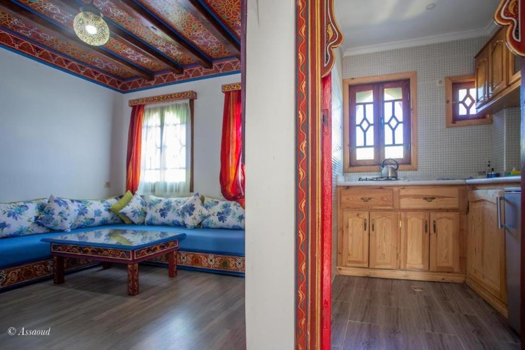 Il comprend un salon avec un canapé bleu et une cuisine. dans l'établissement Guest House Yasmina, à Chefchaouen