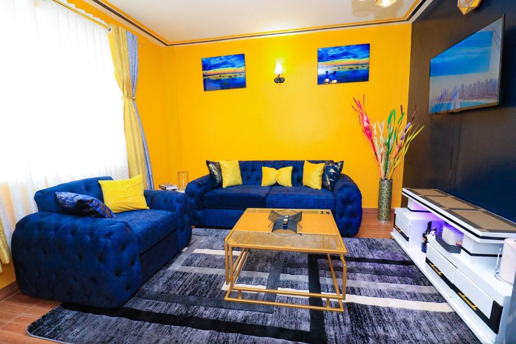 a living room with a blue couch and a table at Joy fully furnished & serviced apartments in Kiambu
