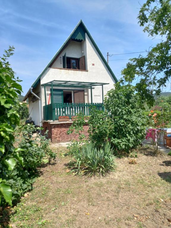 uma pequena casa branca com um telhado verde em View Berry House em Csopak