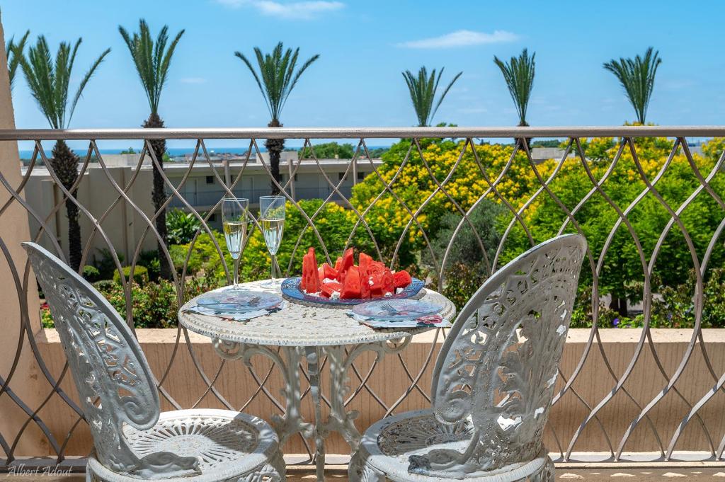 a table and chairs with a plate of fruit on a balcony at Mina's Suites - קיסריה in Caesarea