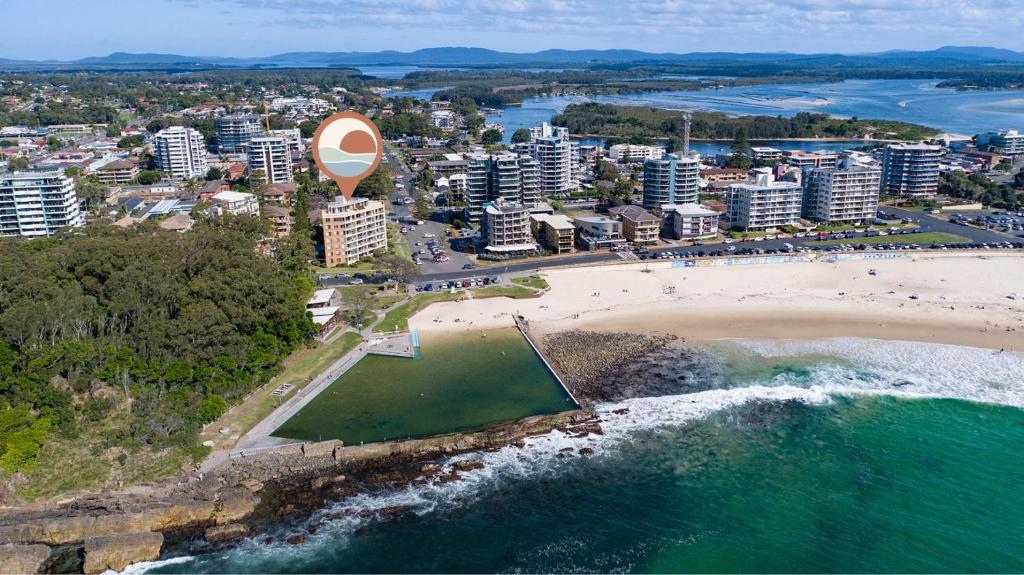 an aerial view of a beach and a city at Beachpoint, Unit 101, 28 North Street in Forster