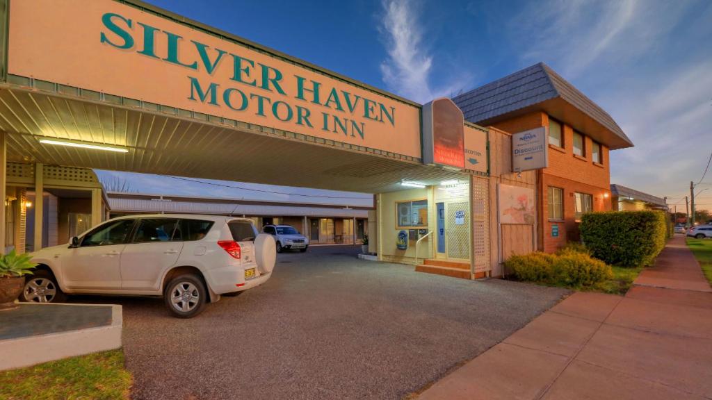 a car parked in a parking lot in front of a motel at Silver Haven Motor Inn in Broken Hill