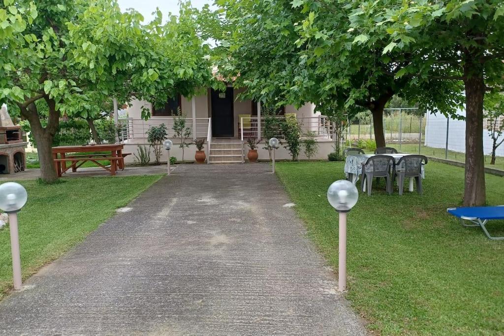 un sentiero che conduce a una casa con tavoli e sedie di Eleni's house a Karianí