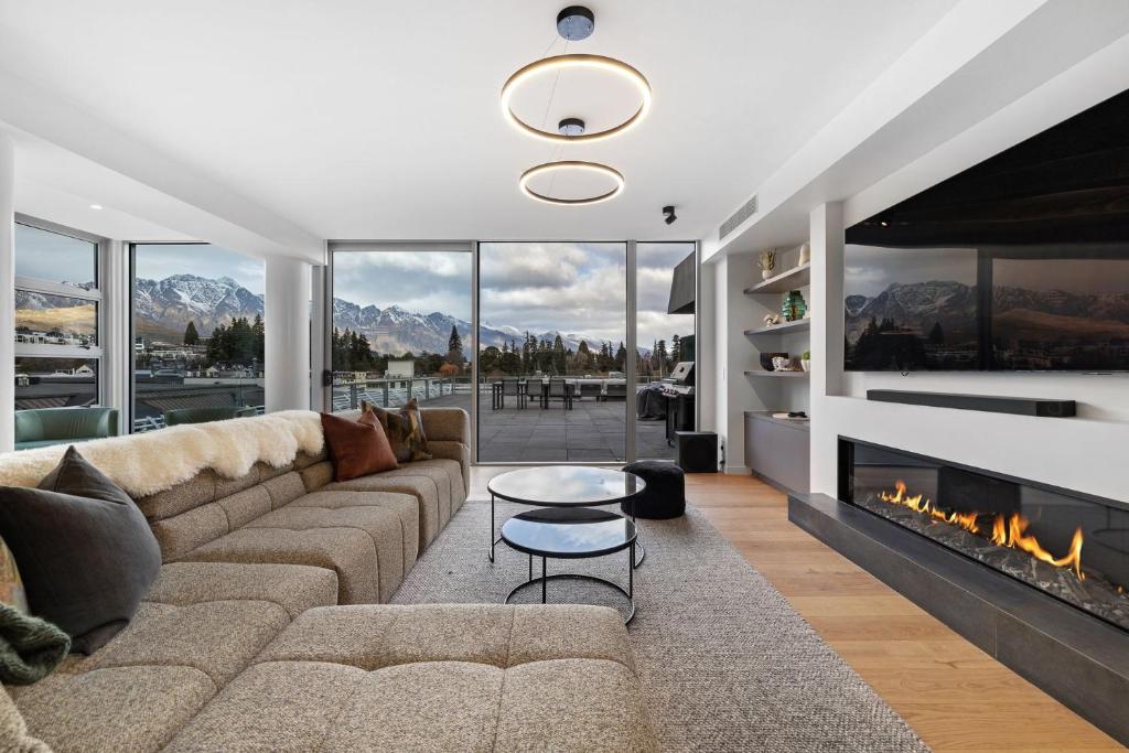a living room with a couch and a fireplace at The Essence of Queenstown in Queenstown