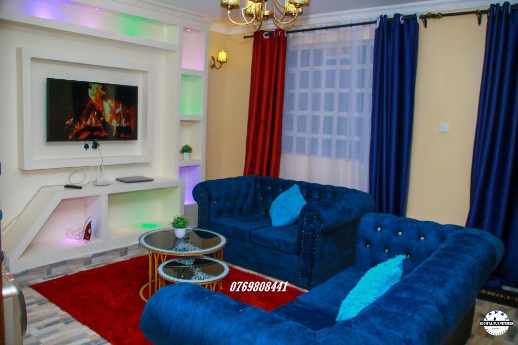 a living room with two blue couches and a fireplace at Denverwing Homes. in Eldoret