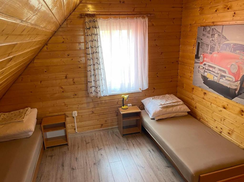 um quarto com duas camas num chalé de madeira em Domki letniskowe Ibiza em Dźwirzyno