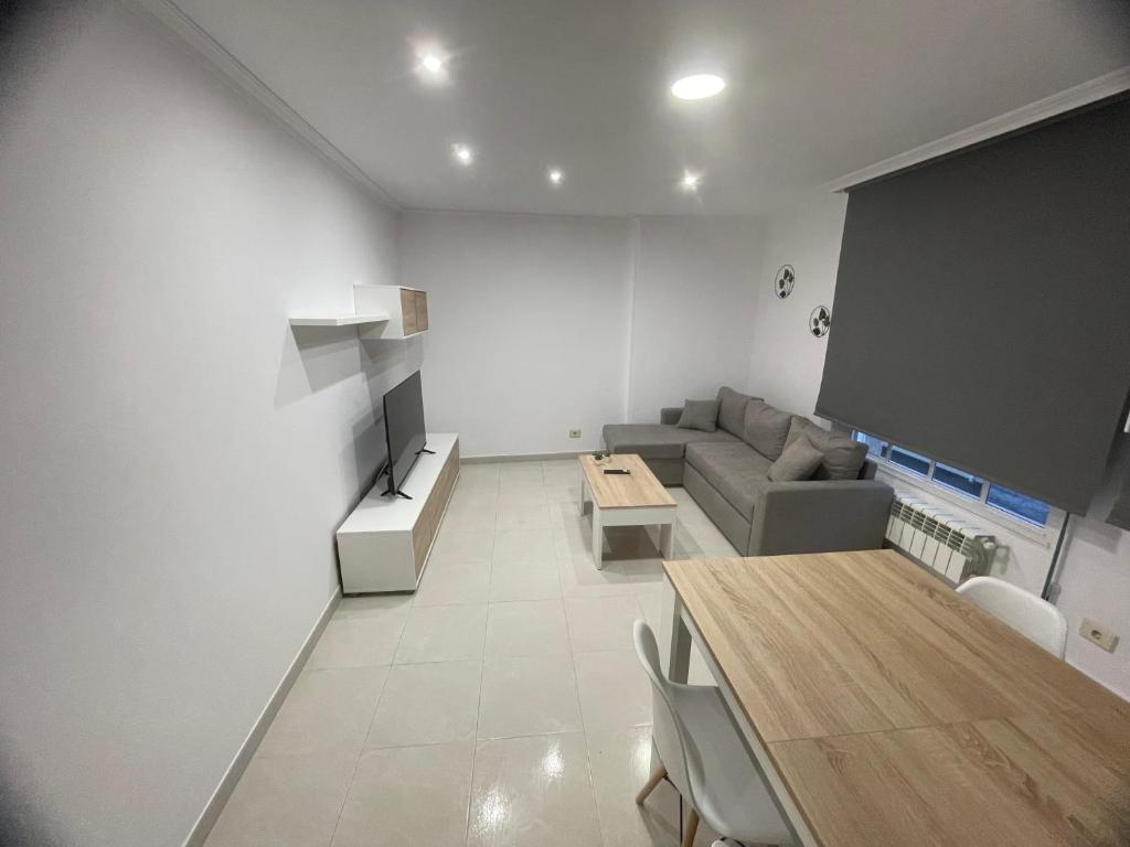 sala de estar con sofá, mesa y pantalla en Apartamentos Demar Luis Casais en O Grove