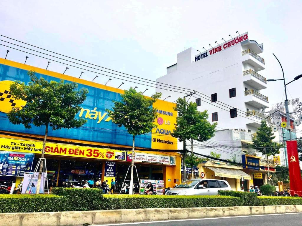 una concurrida calle de la ciudad con un edificio en el fondo en Khách sạn Vĩnh Chương, en Soc Trang