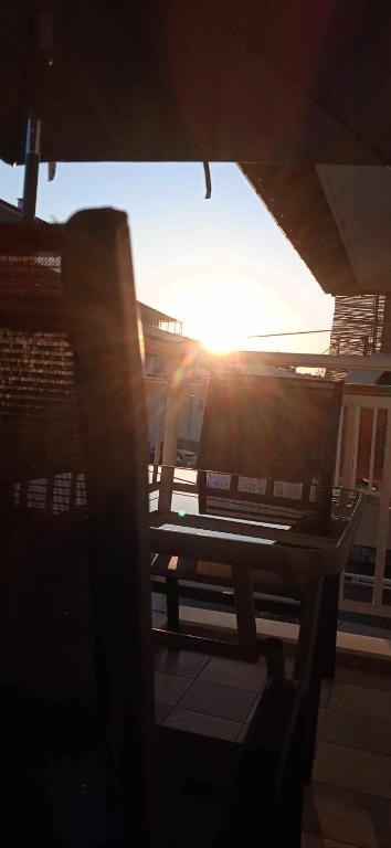 a bench sitting on a porch with the sun setting at Eirini's Hause in Nea Moudania