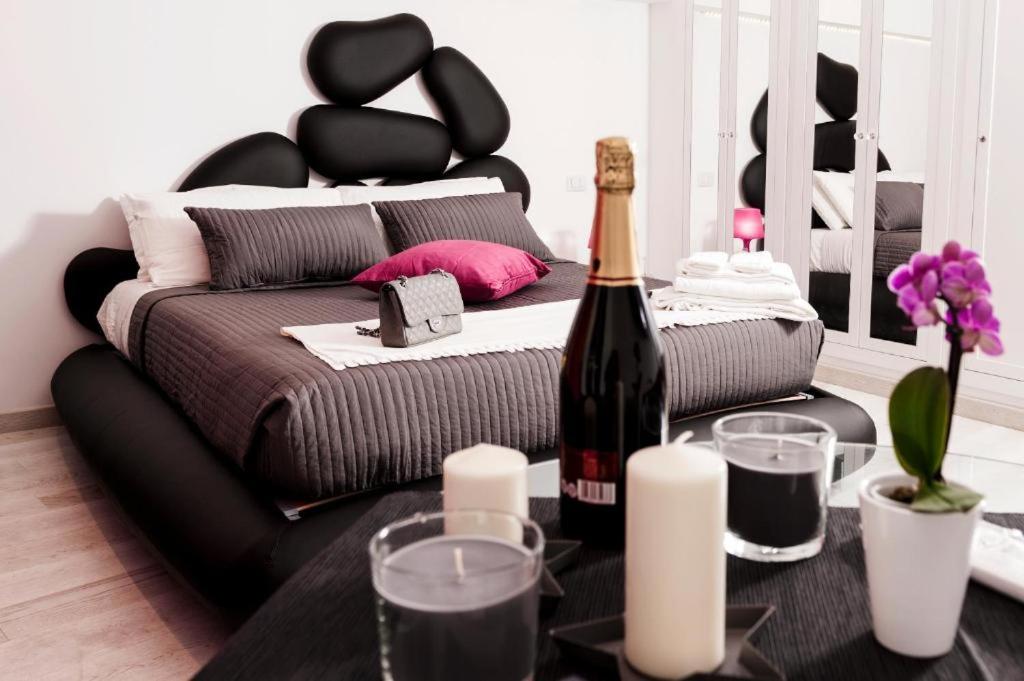 ローマにあるTwo Chic Guesthouseのベッド1台とワイン1本が備わる客室です。