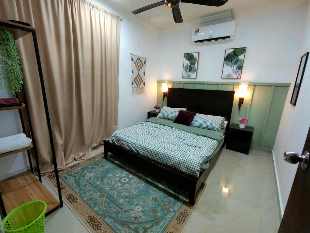a bedroom with a bed and a rug in it at Mini Green Homestay in Kulai