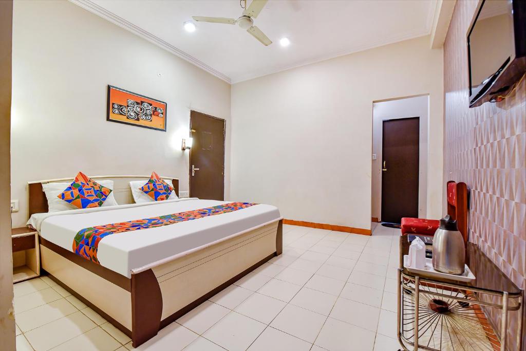 ein Schlafzimmer mit einem Bett und einem TV in der Unterkunft FabHotel Shri Laxmi Palace in Jaipur