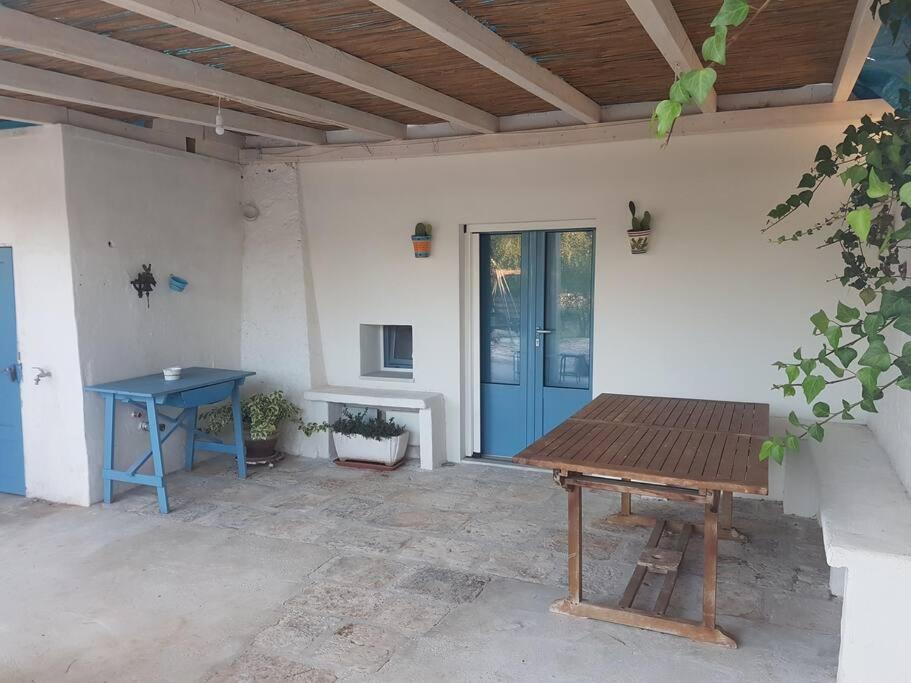 a patio with a blue table and a blue door at Dimora Grecale in Cisternino