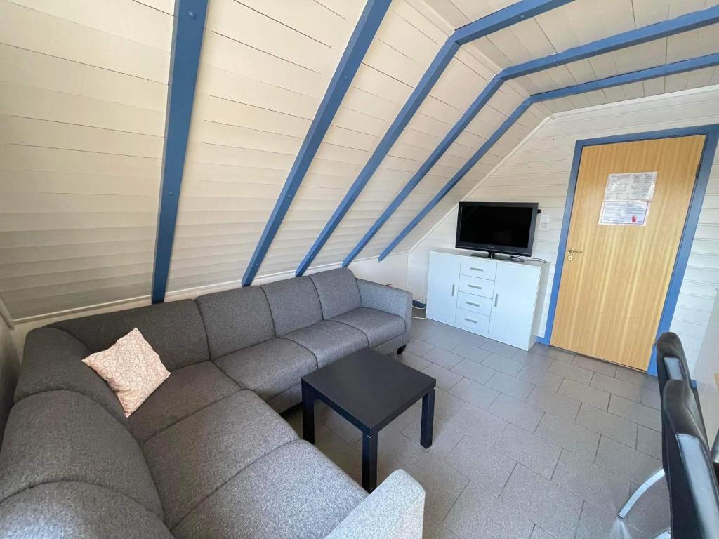 sala de estar con sofá y TV en Nautnes Seaside Apartments A5 en Nautnes