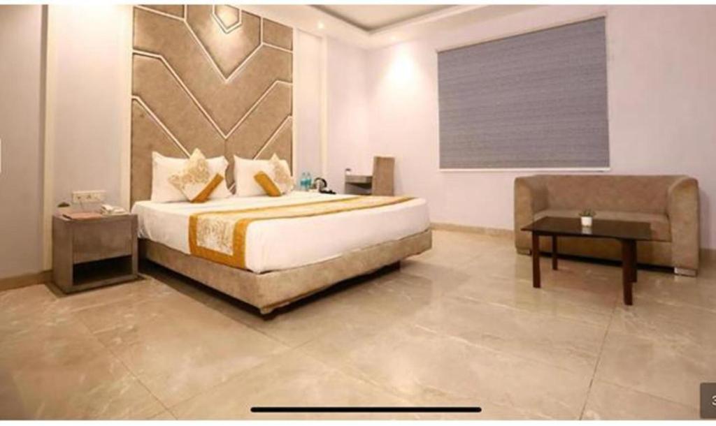 a bedroom with a bed and a couch and a table at FabHotel Prime Anchorage in New Delhi