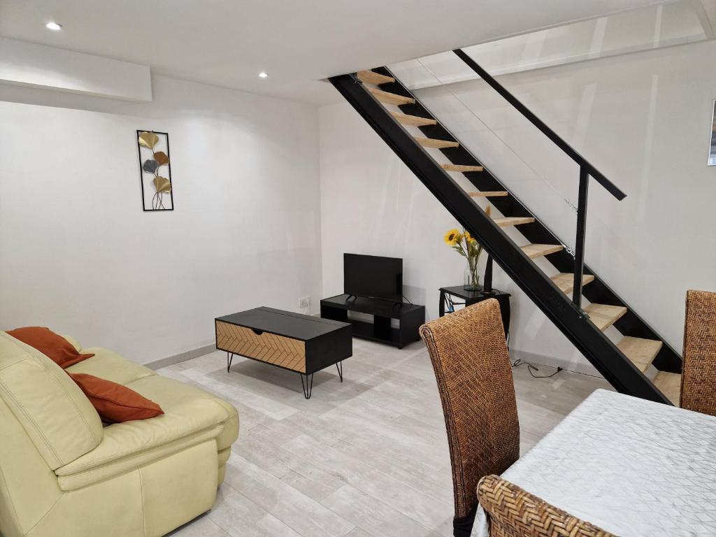 een woonkamer met een bank en een trap bij Maison de village en Provence in Sainte-Tulle
