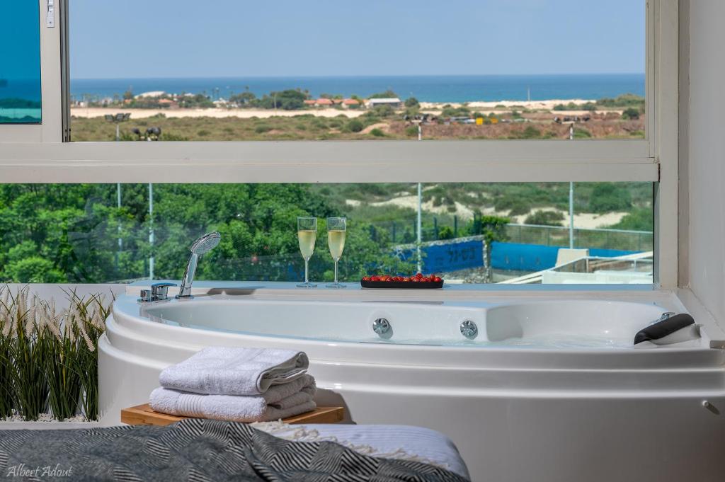 a bath tub in a room with a window at Mina's luxury suite - panoramic sea view- קיסריה in Caesarea