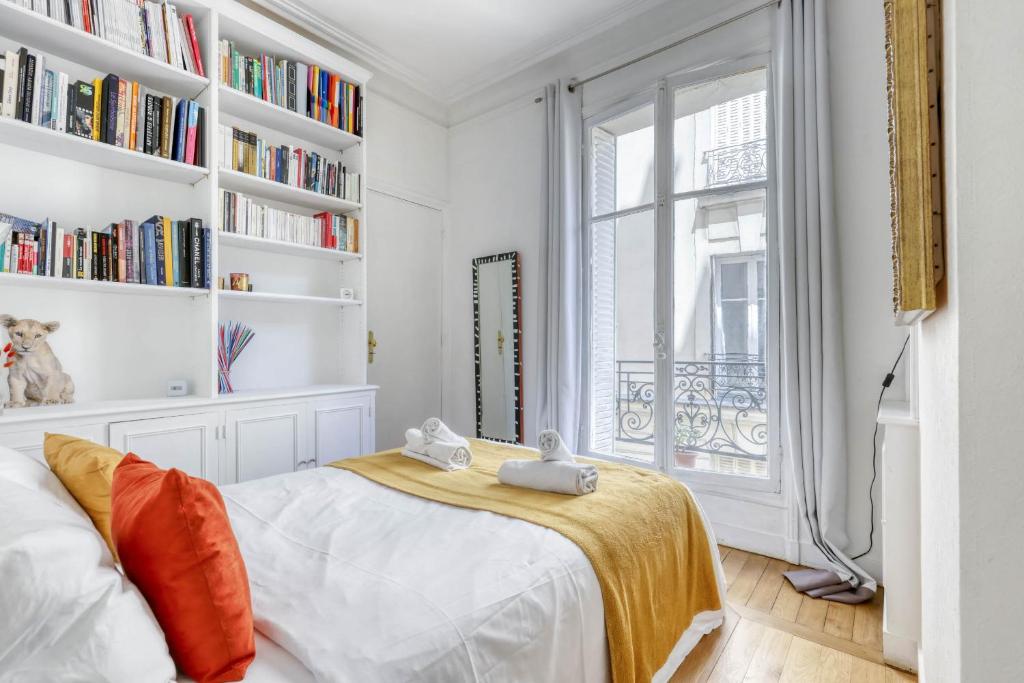 - une chambre avec un lit, une fenêtre et des étagères dans l'établissement Lovely & quiet 1 Bdr Flat at the Luxury 16th Paris, à Paris