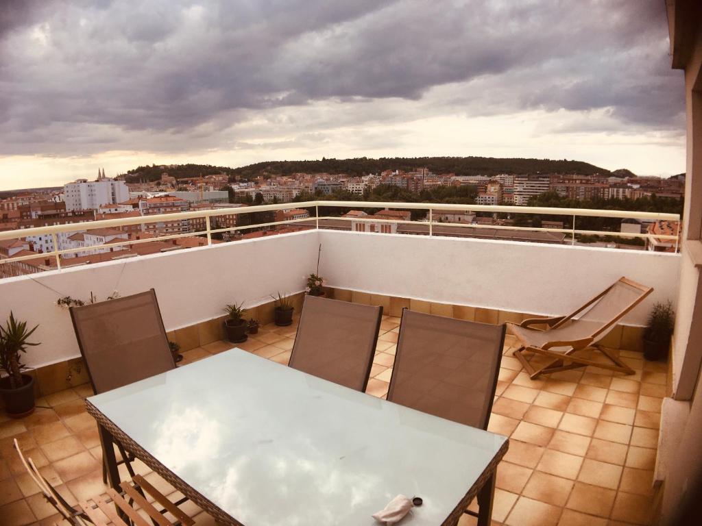 einen Balkon mit einem Tisch und Stühlen auf dem Dach in der Unterkunft Ático 360º de Burgos ATUAIRE in Burgos