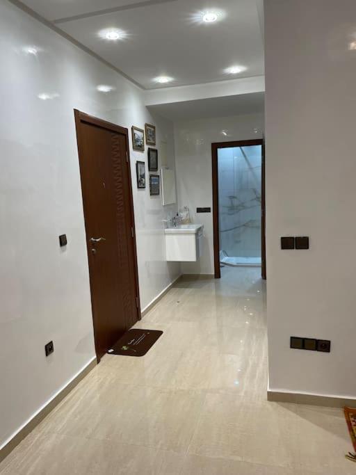 um quarto com um corredor com uma porta e um lavatório em Joli Apt bien situé em Tânger