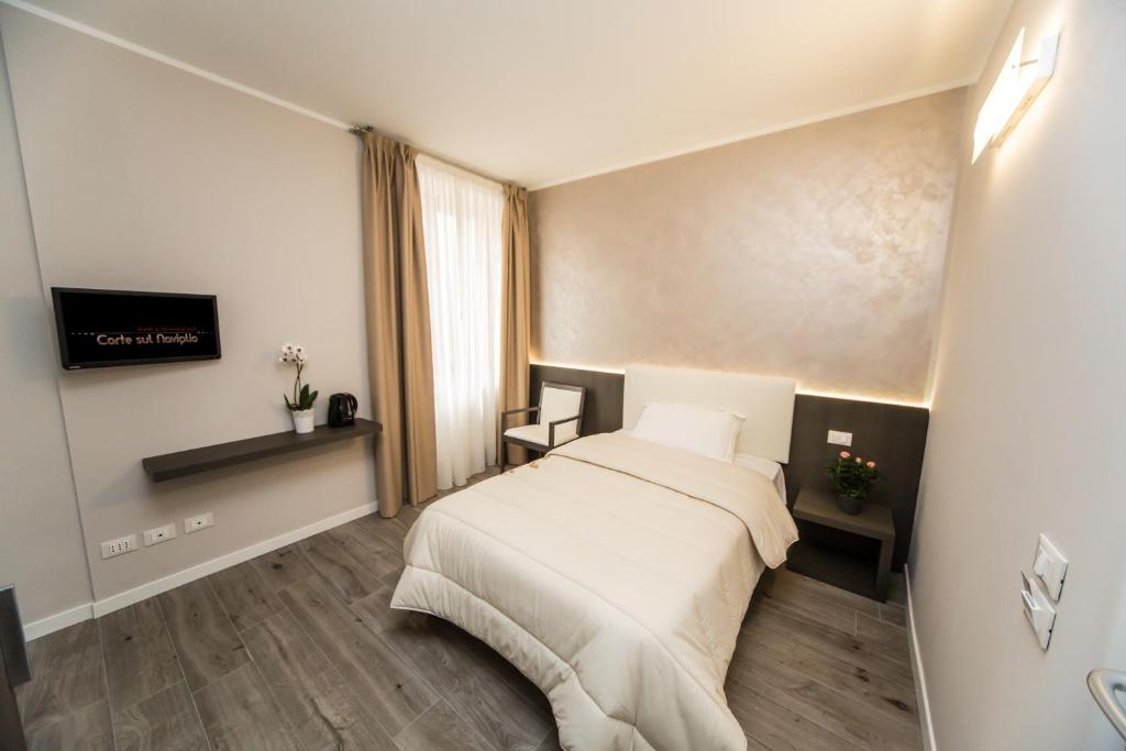 Habitación de hotel con cama y espejo en B&B Corte sul Naviglio en Cernusco sul Naviglio