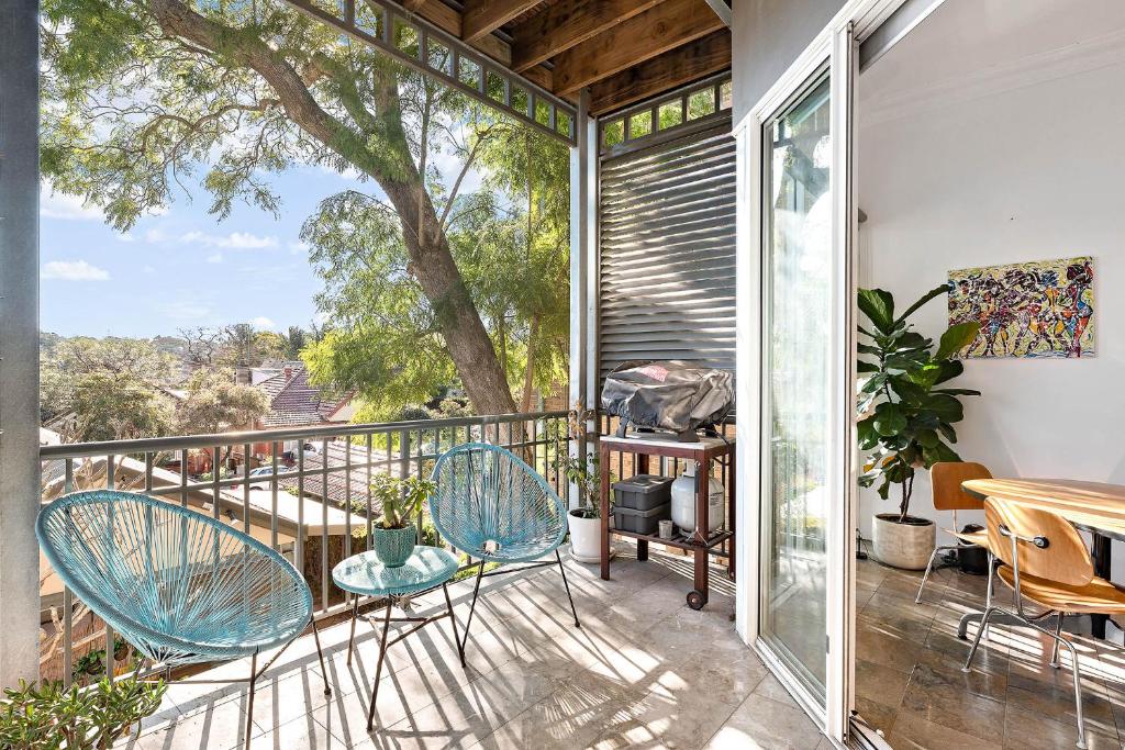 Un balcón con sillas, una mesa y un árbol en Coogee 2 Bedroom Escape - New listing, en Sídney