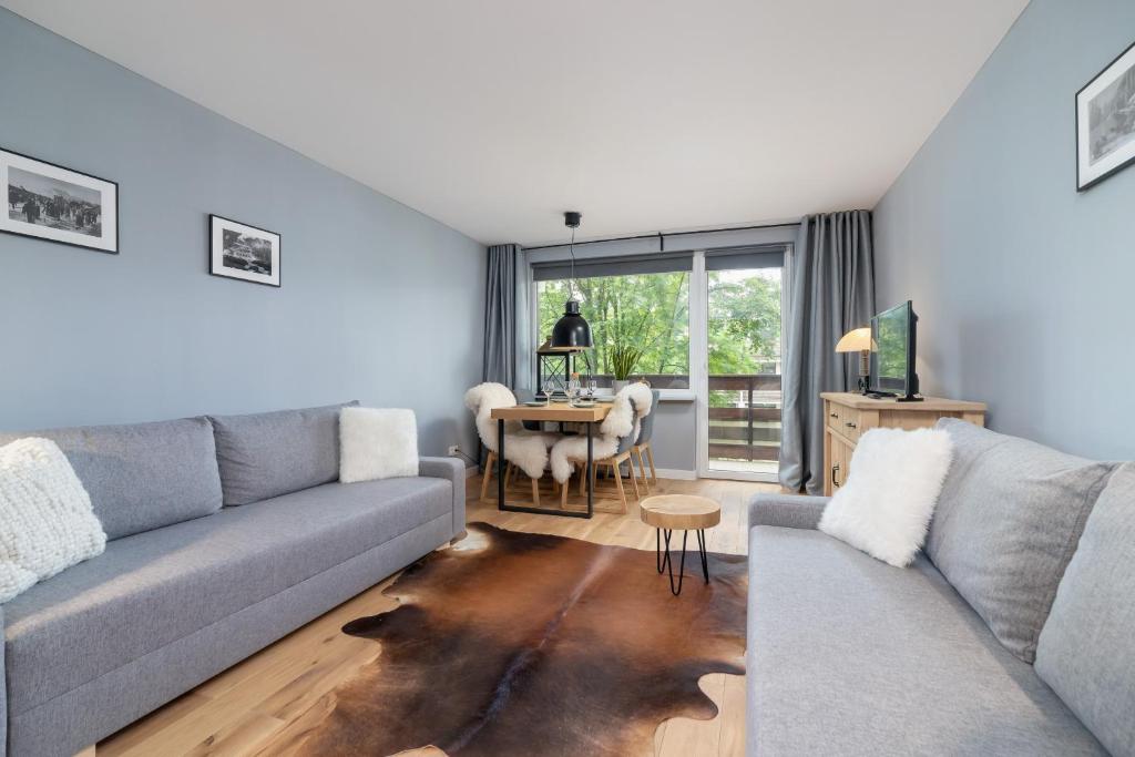 a living room with a couch and a table at Atmospheric Studio Zakopane next to Krupówki by Renters in Zakopane