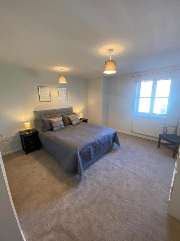 a bedroom with a bed and two lamps and a window at Colchester Smart Two Bed Apartment in Colchester