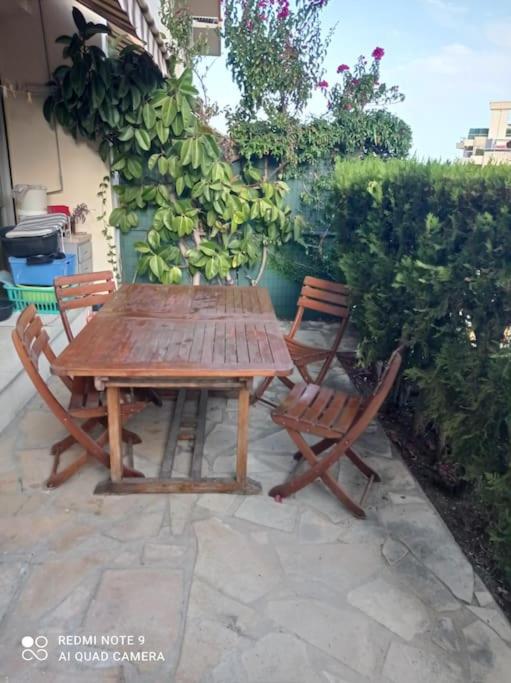 a wooden table and two chairs sitting next to a hedge at Nice Fabron 90 m2 avec Garage in Nice