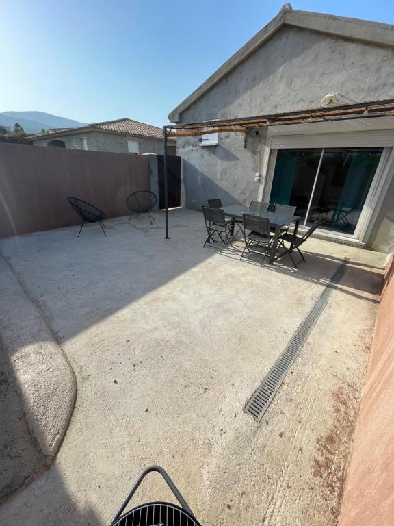 a patio with a table and chairs and a fence at A Ranochja in Ventiseri