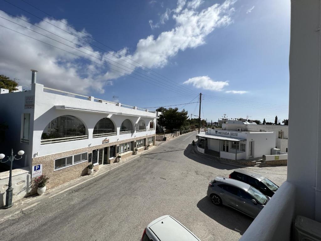 a street with cars parked in front of a building at Hotel Anezina in Drios