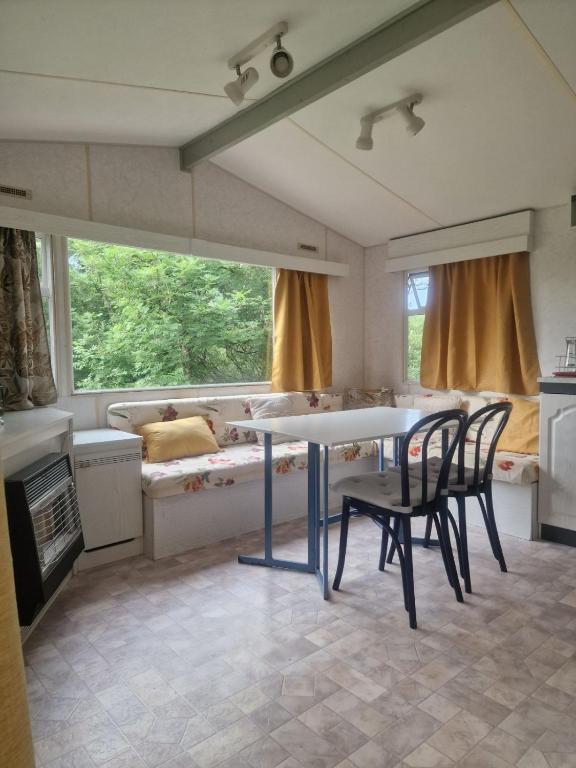 un salon avec une table, des chaises et un canapé dans l'établissement Petit coin tranquille, à Brengues