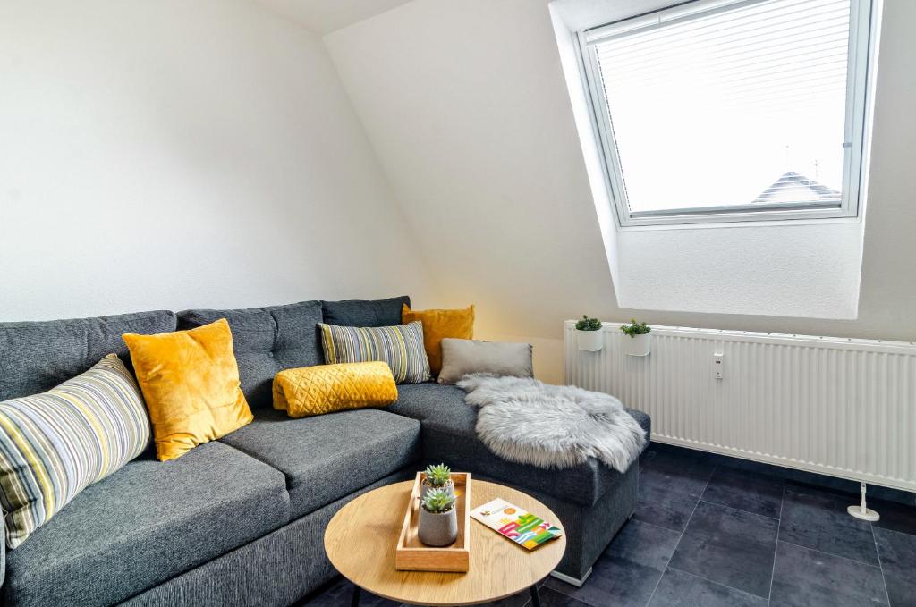 uma sala de estar com um sofá cinzento e uma mesa em Fewo-Keinath em Winterlingen