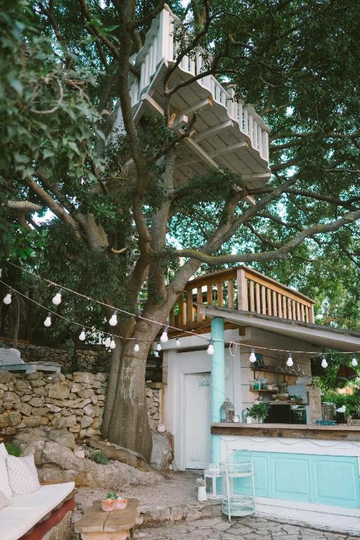 a tree with a deck on top of it at ECO Aparthotel The Dreamers's Club in Lumbarda