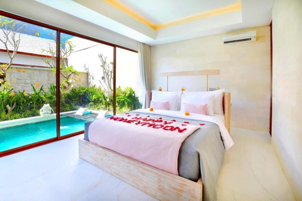 a bedroom with a bed and a swimming pool at La Vie Villa Seminyak by Ini Vie Hospitality in Seminyak