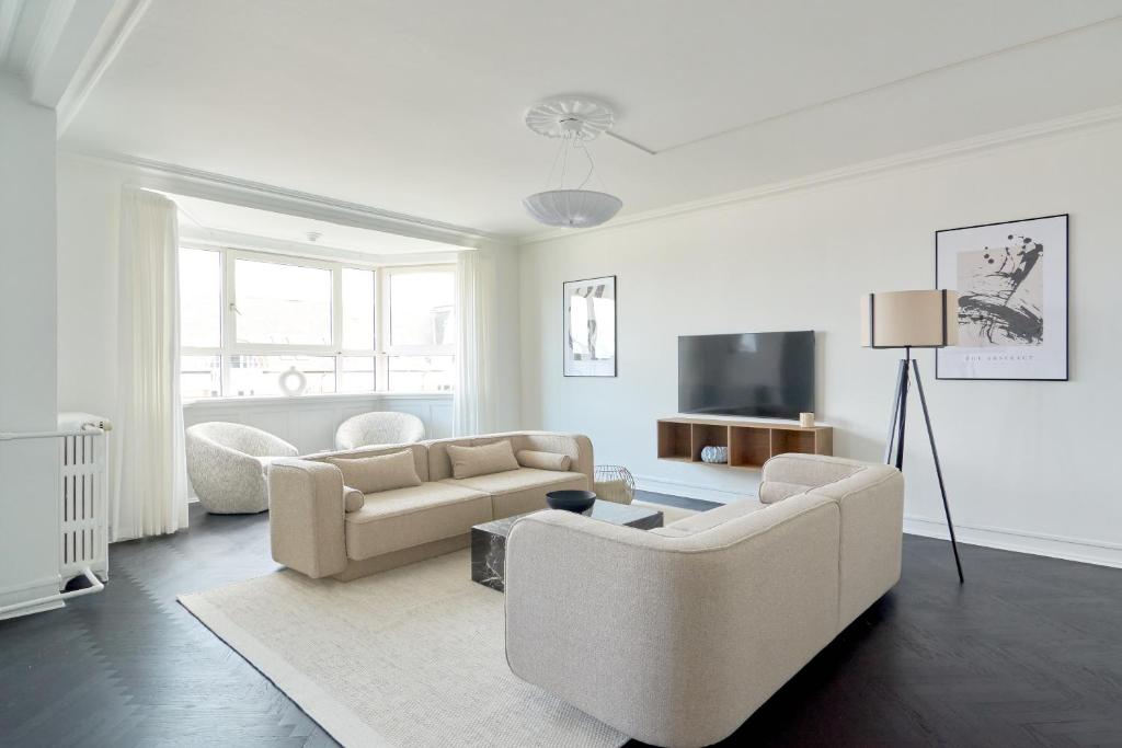 uma sala de estar com dois sofás e uma televisão em Beautiful 3 Bedroom Flat Near Shopping & Metro em Copenhague