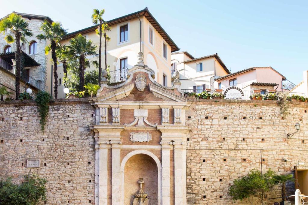 un edificio con una estatua en la parte superior de una pared de ladrillo en Hotel Fonte Cesia, en Todi