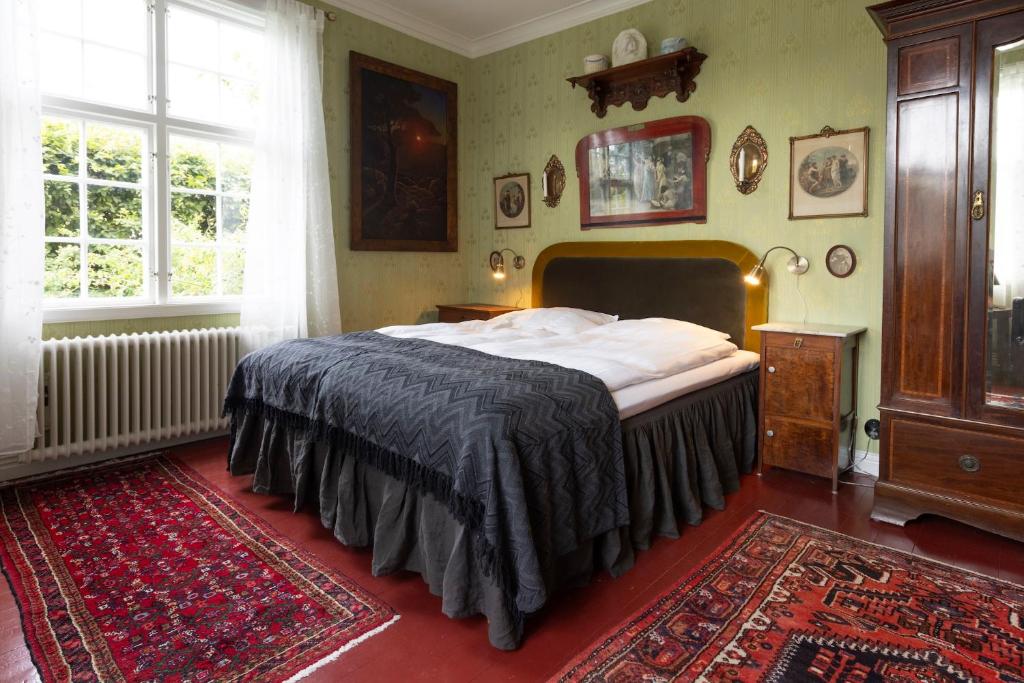 a bedroom with a bed and a large window at Villa Wäring Husrum & Frukost in Varberg