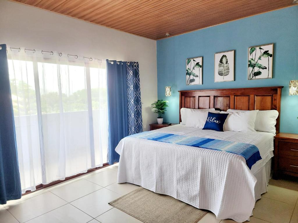 - une chambre avec un grand lit aux murs bleus dans l'établissement Dexamano Hotel & Resort, à Lejamaní