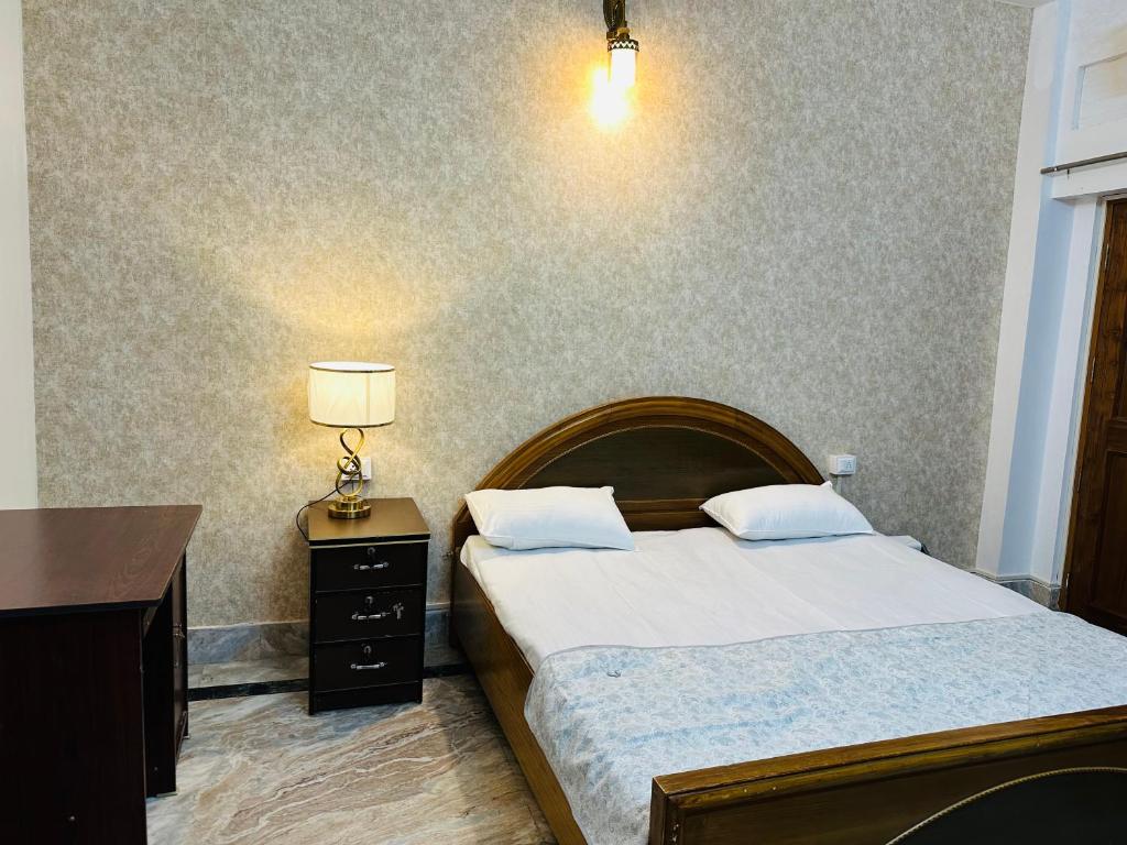 - une chambre avec un lit, un bureau et une lampe dans l'établissement Paridhi, à Varanasi