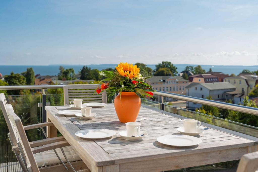 drewniany stół z wazą kwiatów na balkonie w obiekcie Villa am Kreidebruch - Ostseeweitblick w mieście Sassnitz