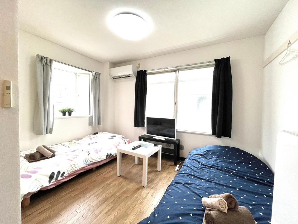 1 dormitorio con 2 camas y TV. en Tokyo Stay Dolce, en Tokio