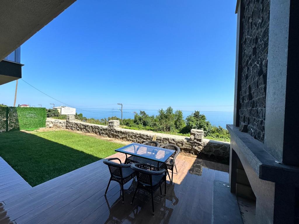 un patio con mesa y sillas en una terraza en Sea View Villa en Trabzon