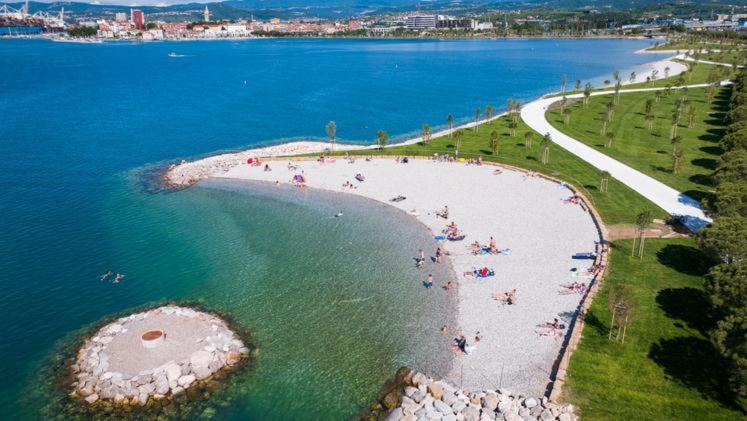 una vista aerea di una spiaggia con persone in acqua di AEGIDA BEACHFRONT apartment a Capodistria