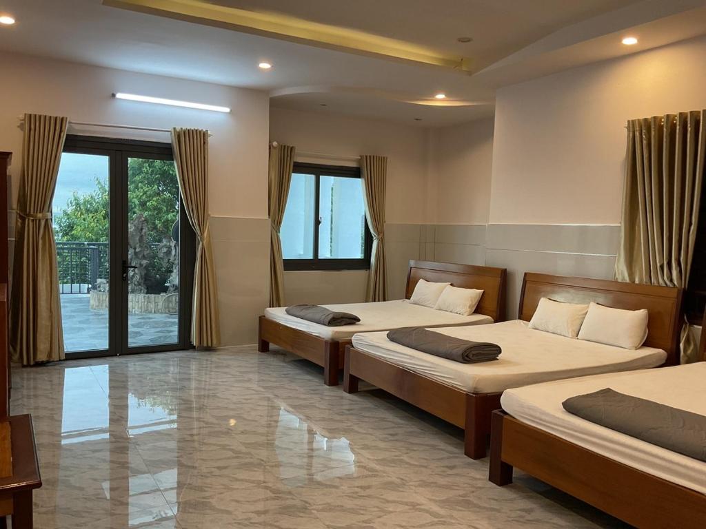 1 dormitorio con 2 camas y ventana grande en Hoàng Linh Hotel en Buon Ma Thuot
